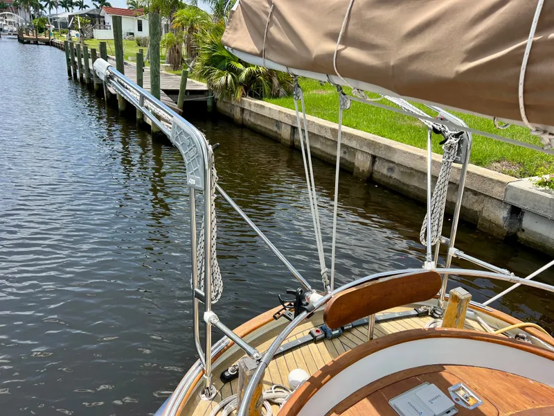 Slide: The Image of Cherubini 44 sailboat, 1986 model, docked in a canal with lush greenery. - 25