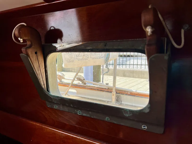 Slide: The Image of 1986 Cherubini 44 boat interior window with wooden frame and nautical view. - 35