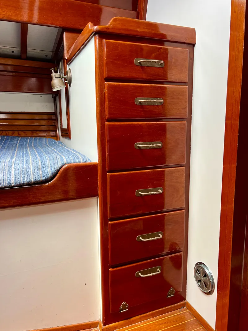 Slide: The Image of 1986 Cherubini 44 interior, wooden drawers and bed with blue striped cushion. - 36