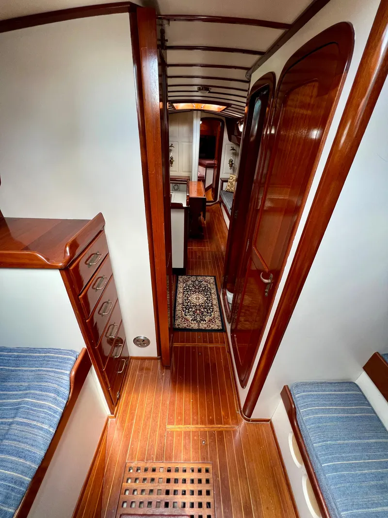 Slide: The Image of Interior of 1986 Cherubini 44 sailboat with wooden floors and blue cushioned seating. - 39