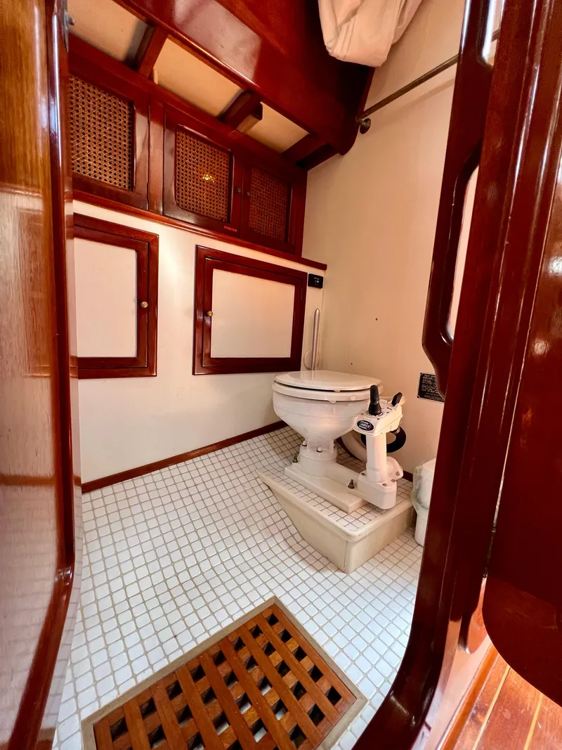 Slide: The Image of 1986 Cherubini 44 yacht bathroom with wooden accents and white tiled floor. - 40