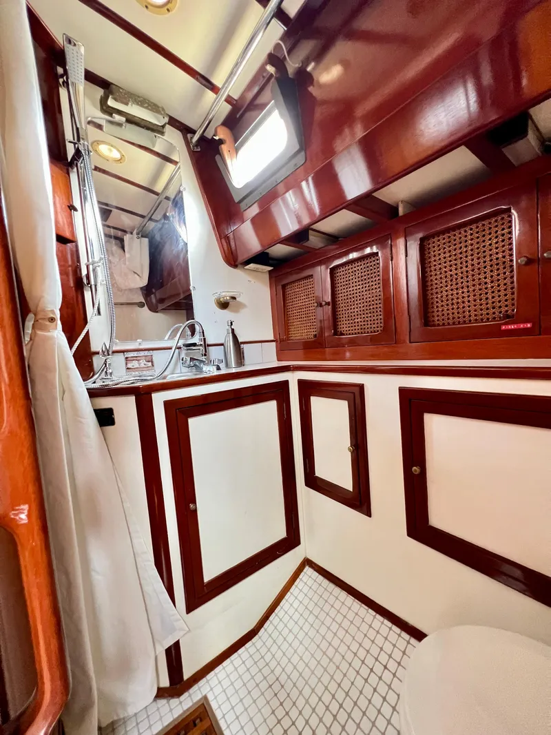 Slide: The Image of 1986 Cherubini 44 yacht bathroom with wooden cabinetry and white tiled floor. - 41