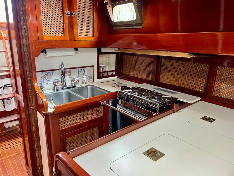 Slide: The Image of 1986 Cherubini 44 yacht kitchen with double sink, stove, and wooden cabinetry. - 42