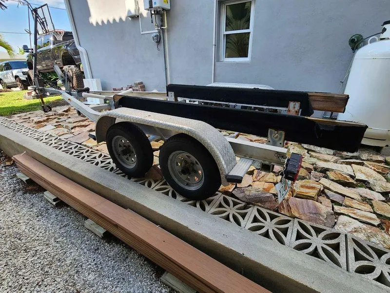 Slide: The Image of Boat trailer for 1976 Boston Whaler 17 Montauk, parked on a stone driveway. - 11