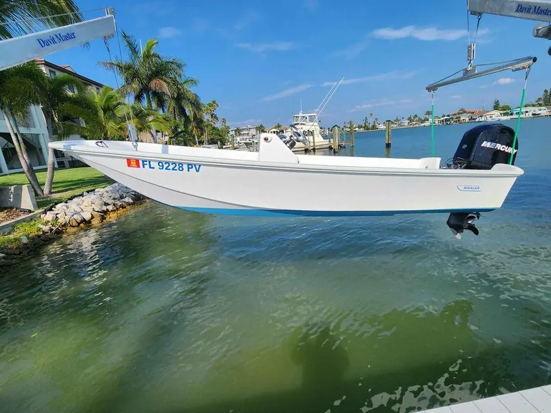 Slide: The Image of 1976 Boston Whaler 17 Montauk boat suspended over water by a dock crane. - 12