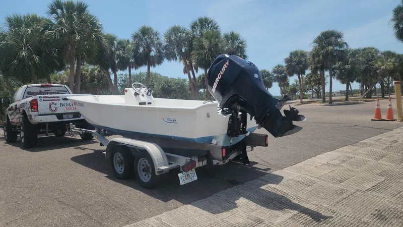 Slide: The Image of 1976 Boston Whaler 17 Montauk boat on trailer, parked near palm trees. - 15