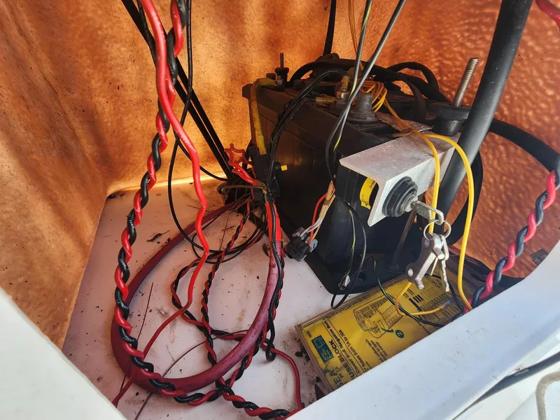Slide: The Image of Battery compartment of a 1976 Boston Whaler 17 Montauk with wiring and keys. - 16