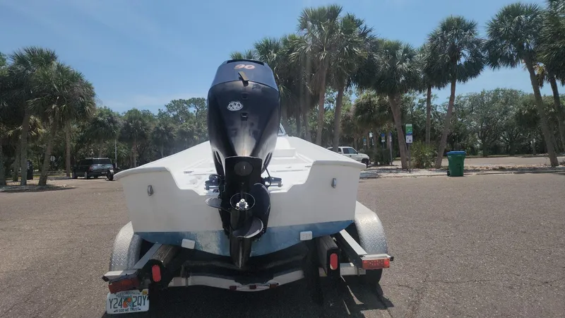 Slide: The Image of 1976 Boston Whaler 17 Montauk boat on trailer, parked near palm trees. - 17