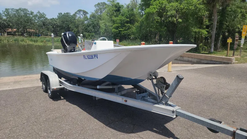 Slide: The Image of 1976 Boston Whaler 17 Montauk boat on trailer near a lake, ready for launch. - 18