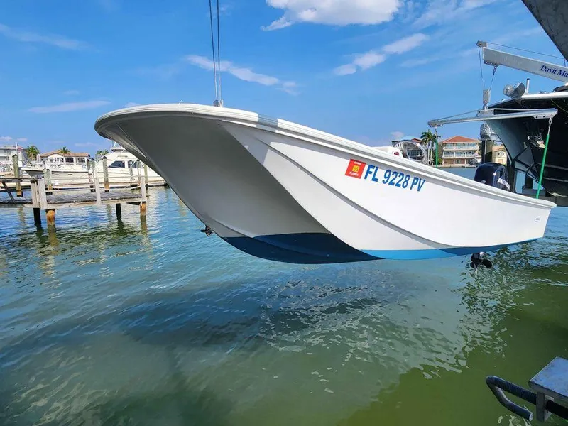 Slide: The Image of 1976 Boston Whaler 17 Montauk boat being lifted from water at a marina. - 2