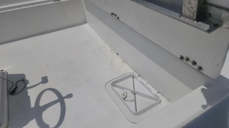 Slide: The Image of 1976 Boston Whaler 17 Montauk boat interior with storage compartment and steering wheel shadow. - 21