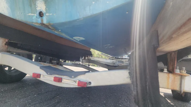 Slide: The Image of 1976 Boston Whaler 17 Montauk boat on trailer, underside view showing hull and trailer details. - 31