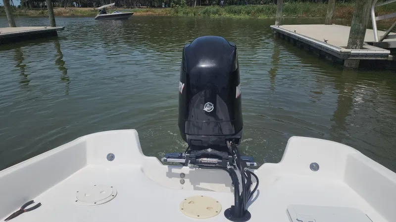 Slide: The Image of 1976 Boston Whaler 17 Montauk boat with outboard motor on calm water near docks. - 39