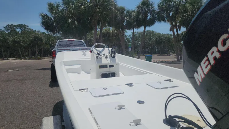 Slide: The Image of 1976 Boston Whaler 17 Montauk boat on trailer, parked near palm trees. - 41