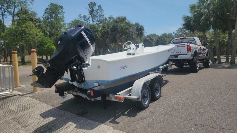 Slide: The Image of 1976 Boston Whaler 17 Montauk boat on trailer, parked near trees and truck. - 45