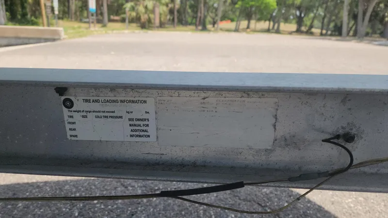 Slide: The Image of Sticker on a 1976 Boston Whaler 17 Montauk trailer, displaying tire and loading information. - 47