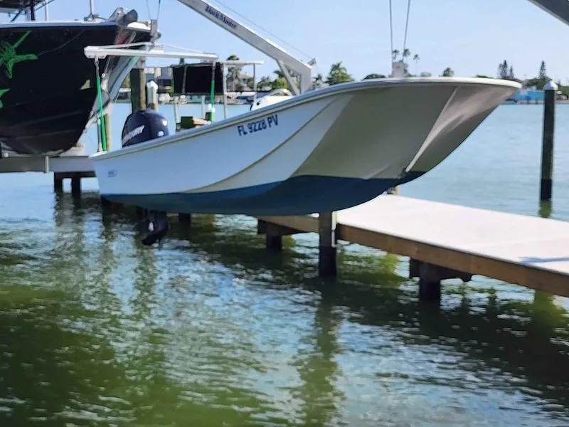 Slide: The Image of 1976 Boston Whaler 17 Montauk boat docked on a lift over water. - 8