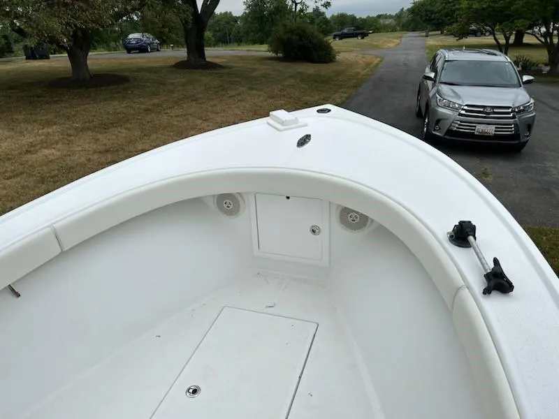 Slide: The Image of 2012 Onslow Bay 20 boat bow with white interior, parked near a driveway. - 10