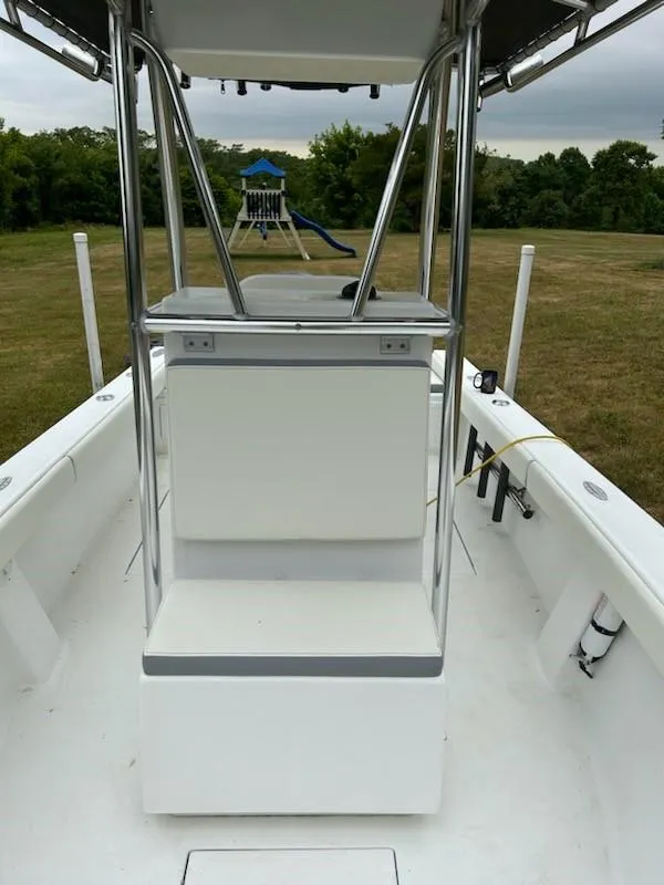 Slide: The Image of 2012 Onslow Bay 20 boat interior with seating and rod holders, set in a grassy area. - 11