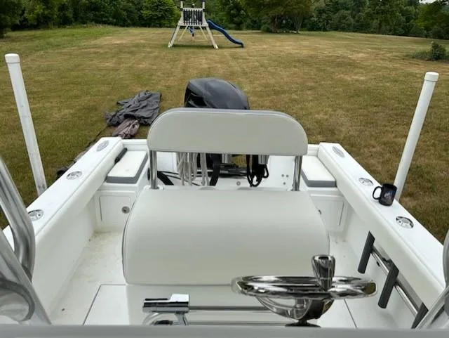 Slide: The Image of 2012 Onslow Bay 20 boat interior with white seating, parked on grassy field. - 12