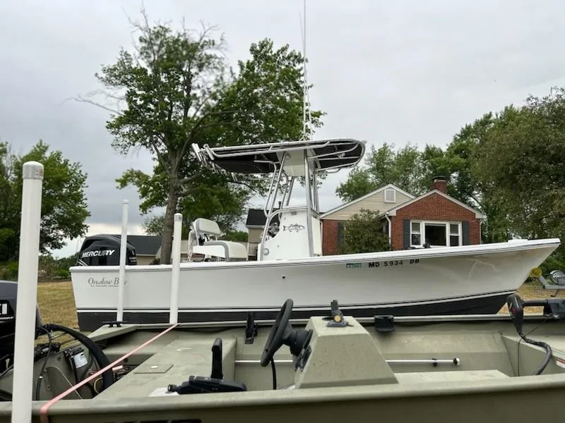 Slide: The Image of 2012 Onslow Bay 20 boat parked outdoors near a house and trees. - 15