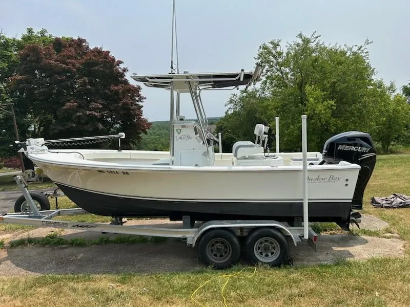 Slide: The Image of 2012 Onslow Bay 20 boat on trailer, parked outdoors with trees in the background. - 16