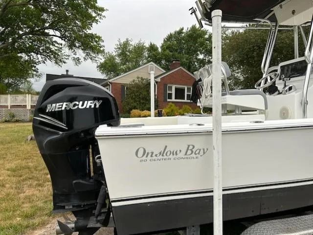 Slide: The Image of 2012 Onslow Bay 20 boat with Mercury engine, parked near a brick house. - 5