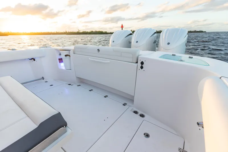 Slide: The Image of 2024 Edgewater 370CC boat interior with triple outboard engines at sunset. - 12