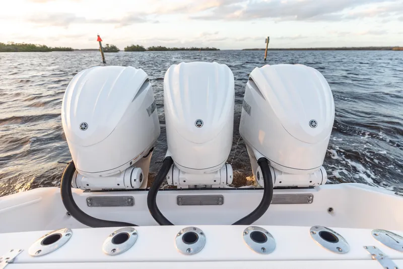Slide: The Image of 2024 Edgewater 370CC boat with triple outboard engines on the water. - 14