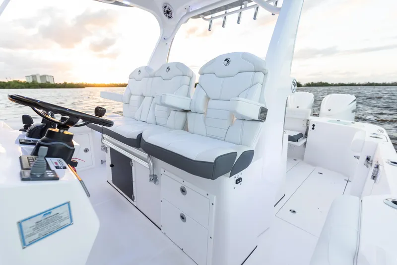 Slide: The Image of 2024 Edgewater 370CC boat interior with white seating and helm station. - 2