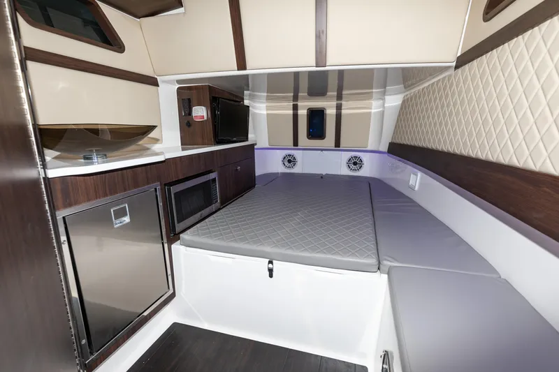 Slide: The Image of 2024 Edgewater 370CC cabin interior with bed, microwave, and refrigerator. - 3