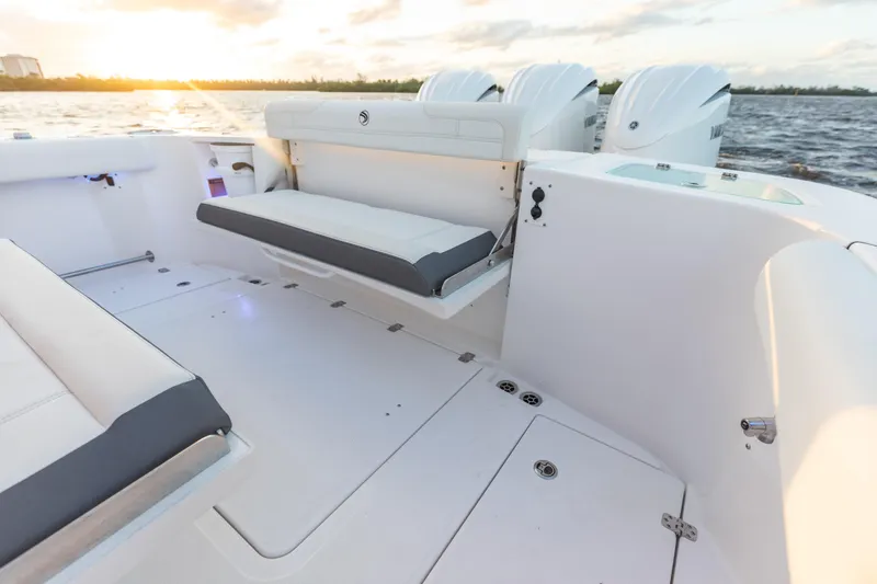 Slide: The Image of 2024 Edgewater 370CC boat interior with foldable seating and triple outboard engines. - 6