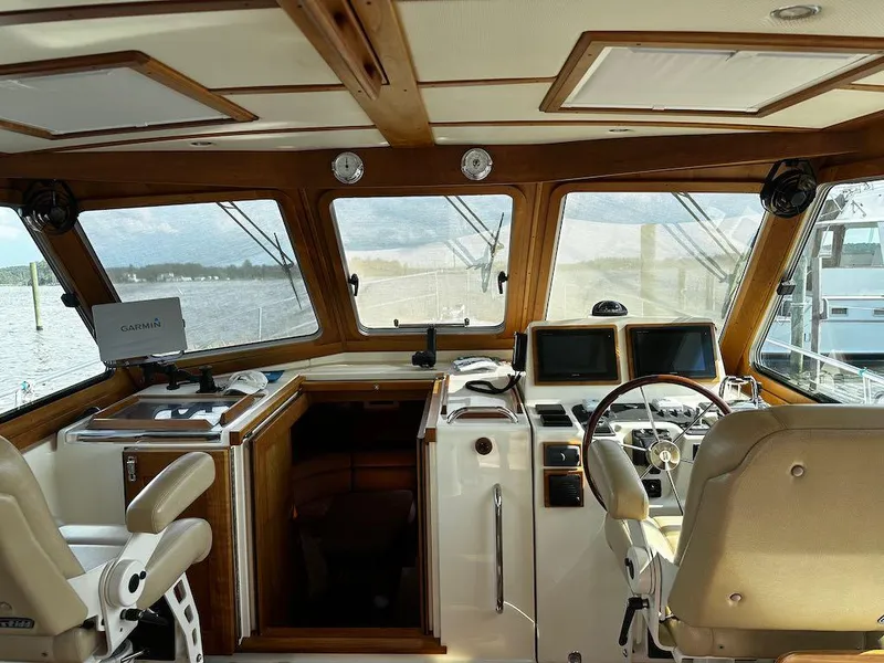 Slide: The Image of 2008 Sabre 42 Hard Top Express helm with dual screens and leather seating, overlooking marina. - 2