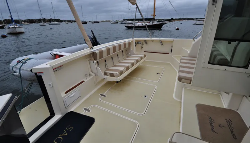 Slide: The Image of 2008 Sabre 42 Hard Top Express boat deck with seating, docked in a marina. - 26