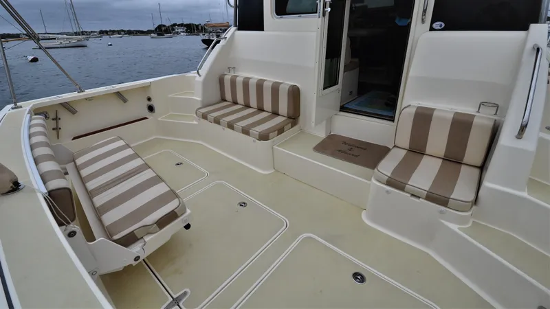 Slide: The Image of 2008 Sabre 42 Hard Top Express boat with striped seating, docked by the water. - 31