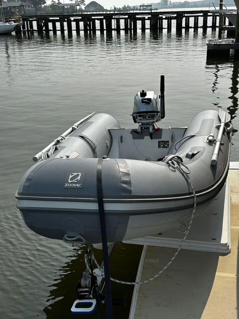 Slide: The Image of Inflatable Zodiac boat docked on calm water near wooden pier. - 33