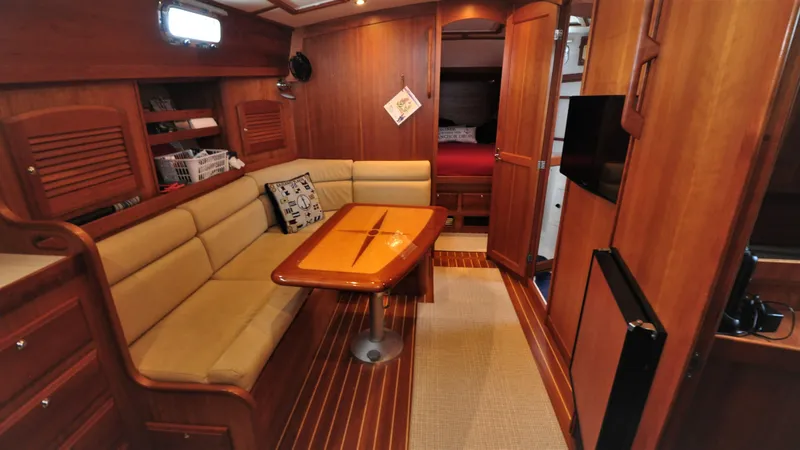 Slide: The Image of 2008 Sabre 42 Hard Top Express interior with wood finish, beige seating, and dining table. - 38