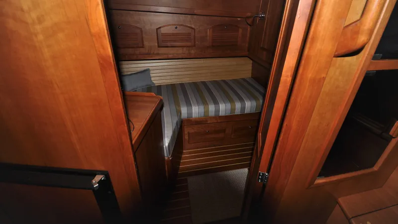 Slide: The Image of 2008 Sabre 42 Hard Top Express cabin with wooden interior and striped bedding. - 42