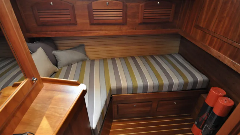 Slide: The Image of Cozy cabin interior of 2008 Sabre 42 Hard Top Express with striped bedding and wooden finish. - 43