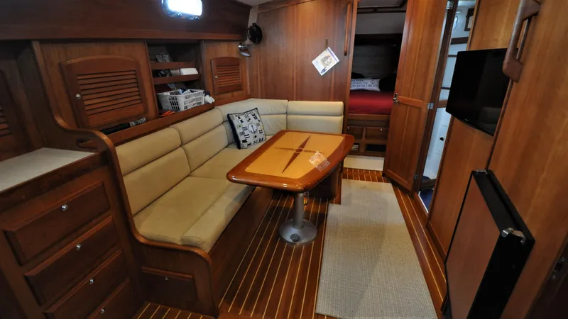 Slide: The Image of 2008 Sabre 42 Hard Top Express interior with wooden finishes, beige seating, and dining table. - 44