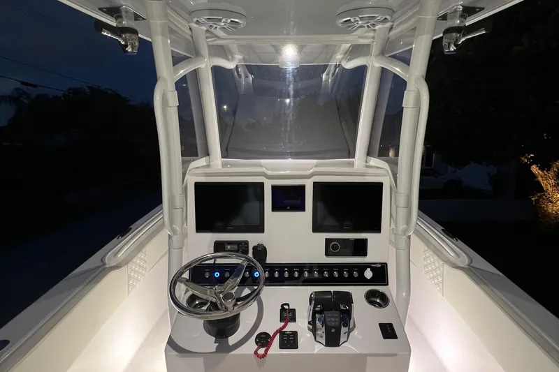 Slide: The Image of 2022 Streamline 26TE boat cockpit with illuminated dashboard and dual screens at night. - 3