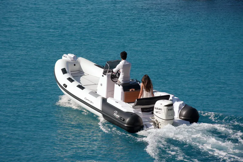 Slide: The Image of 2023 Ranieri CAYMAN 21 SPORT boat cruising on clear blue water. - 2