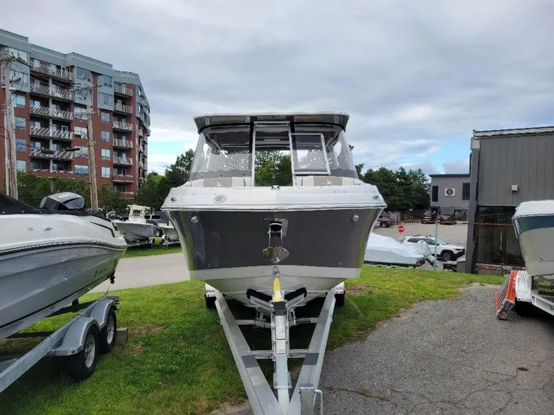 Slide: The Image of 2024 Finseeker 280 DC boat on trailer, parked outdoors near buildings. - 17