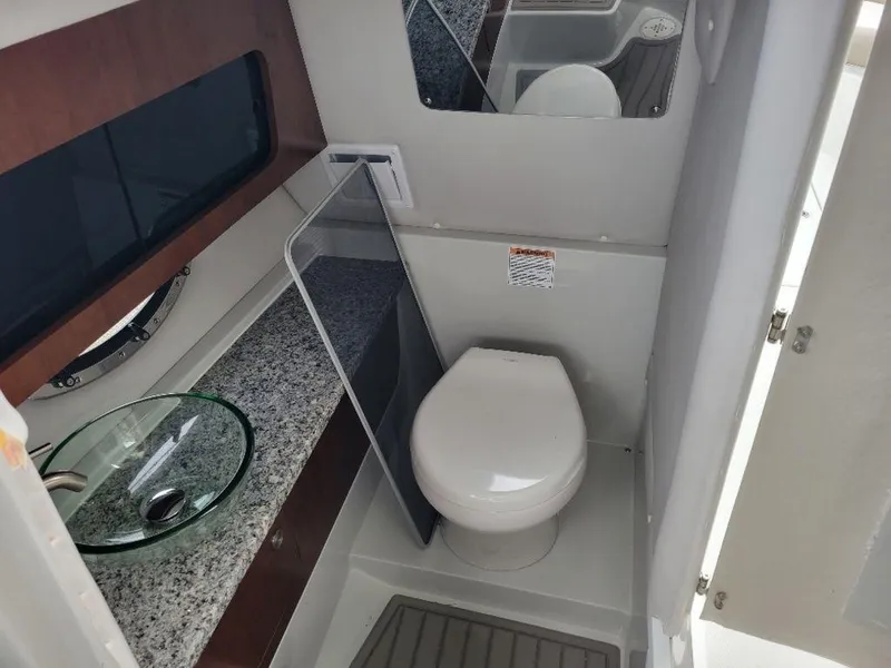 Slide: The Image of 2024 Finseeker 280 DC boat bathroom with modern fixtures and granite countertop. - 6