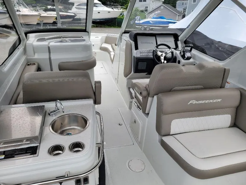 Slide: The Image of 2024 Finseeker 280 DC boat interior with helm, seating, and kitchenette. - 7