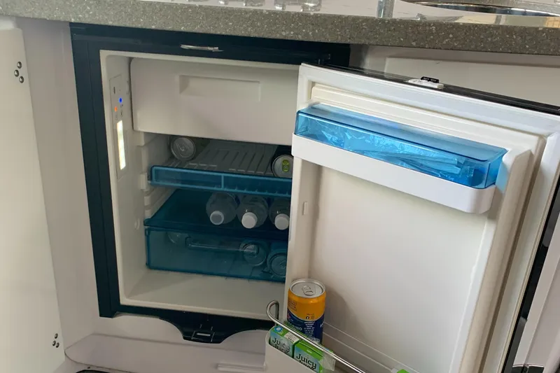 Slide: The Image of Mini fridge stocked with drinks on 2019 Four Winns H290 OB boat. - 21
