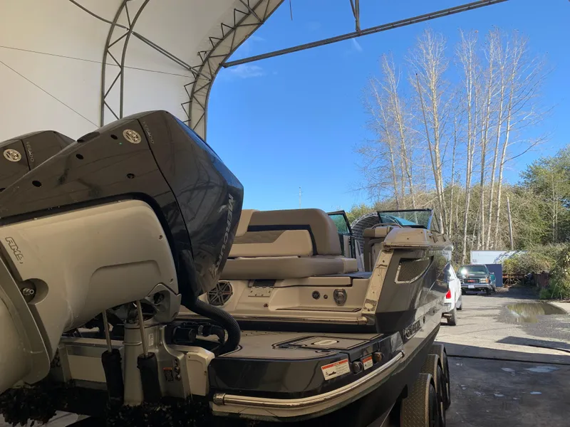 Slide: The Image of 2019 Four Winns H290 OB boat with dual outboard engines in a covered storage area. - 25