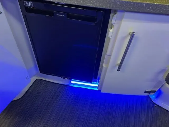 Slide: The Image of 2019 Four Winns H290 OB interior with fridge and blue LED lighting. - 33