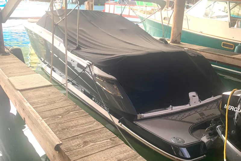 Slide: The Image of 2019 Four Winns H290 OB boat docked with cover, side view. - 4