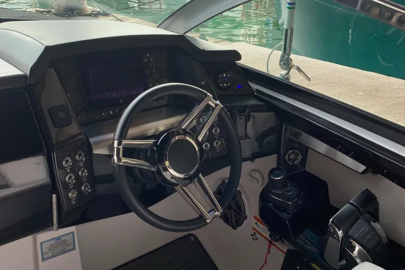 Slide: The Image of 2019 Four Winns H290 OB boat cockpit with steering wheel and control panel. - 9